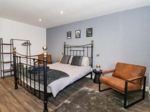a bedroom with a bed and a chair at Chalet 2 in Ganton