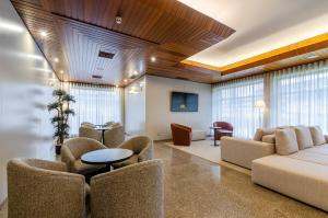 a waiting room with a couch and chairs and a table at TURIM Santa Maria da Feira Hotel in Santa Maria Da Feira