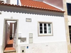a white house with a window and a door at Villa 2 Quartos by WOT Lodge Soul in Ericeira