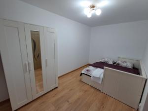 a white bedroom with a bed and a closet at "NIB's apartment" in Caransebeş