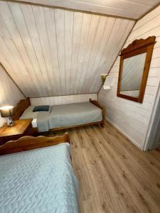 a room with two beds and a window in a attic at Grey House Istebna in Istebna