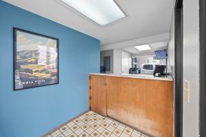 an office with a blue wall and a reception desk at Hotel Milagro in Chula Vista