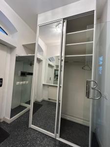 a glass door in a room with a mirror at Apartament Krzemienna in Bielsko-Biała