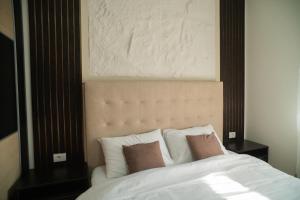 a white bed with two pillows on top of it at Nedodjija apartman in Leskovac