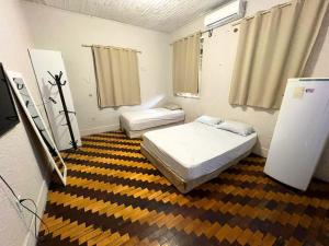 a room with two beds and a television in it at Pousada Estilo Brasil in Fortaleza