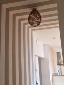 a room with striped walls and a pendant light at Le Damier in Castres