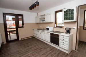 a kitchen with white cabinets and a counter top at Pensiunea Teona in Târgu Ocna