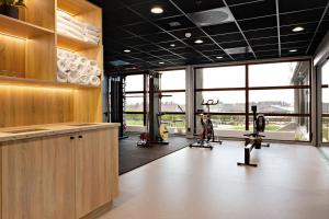 a gym with treadmills and exercise equipment and windows at Radisson Hotel Haugesund in Haugesund