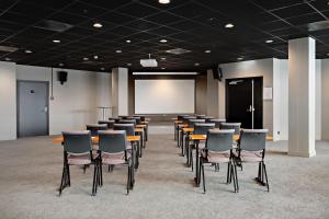 a conference room with chairs and a white screen at Radisson Hotel Haugesund in Haugesund