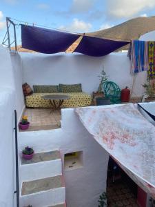 a white house with a couch and a table at casa tradicional marroqui in Sidi Ifni +19 photos