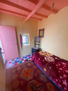 a bedroom with a bed and a chair in a room at casa tradicional marroqui in Sidi Ifni