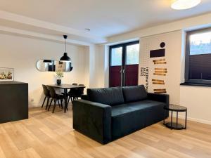 a living room with a couch and a table at Apartamenty Polna Park in Duszniki Zdrój