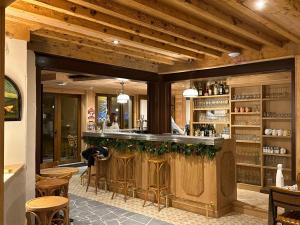 eine Bar in einem Restaurant mit Holzdecken und Stühlen in der Unterkunft Café-Hôtel Le Morillon, Domaine du Grand Massif-Samoëns in Morillon