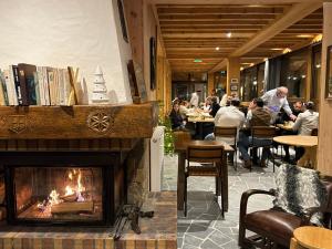 ein Kamin in einem Restaurant mit Gästen an Tischen in der Unterkunft Café-Hôtel Le Morillon, Domaine du Grand Massif-Samoëns in Morillon
