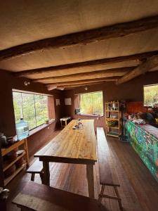 a large room with a wooden table and windows at Wallpari Sonqo temazcal hostel Comunidad in Pisac