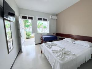 a bedroom with a white bed and a blue chair at Pousada Acalanto in Aracaju +45 photos