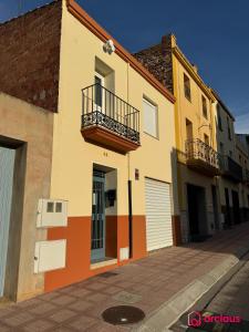 a building with two balconies on a street at El Piso Bajo in San Juan de Moró
