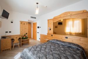 a bedroom with a large bed and a desk at Hotel Ristorante Alla Nave in Lavis +65 photos