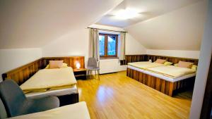 a room with two beds and a chair in it at Apartmány Villa Severka in Starý Smokovec