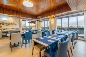 a dining room with tables and chairs and windows at TURIM Santa Maria da Feira Hotel in Santa Maria Da Feira