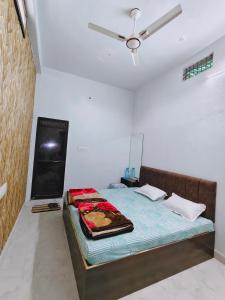 a bed in a room with a ceiling fan at Shiv Lehri Homestay in Ujjain