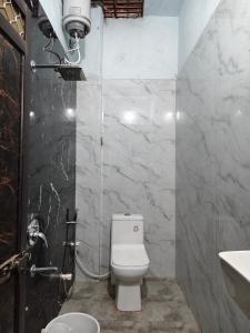 a bathroom with a white toilet and a sink at Shiv Lehri Homestay in Ujjain