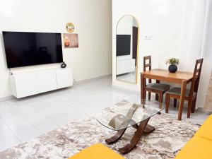 a living room with a television and a dining room table at F2 Appart Les Ambassades Point E, Dakar in Dakar