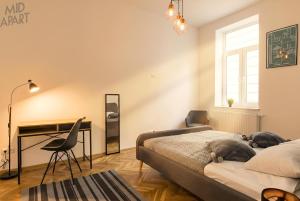 a bedroom with two beds and a desk with a dog on the bed at Mid Apart Mennicza Cieszyn in Cieszyn