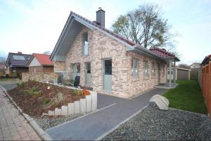 a small brick house with a pathway in front of it at Feriendorf Südstrand Haus 11 in Pelzerhaken