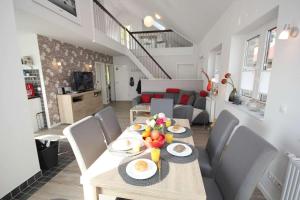 a dining room and living room with a table and chairs at Feriendorf Südstrand Haus 11 in Pelzerhaken