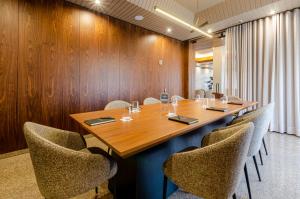 a conference room with a wooden table and chairs at TURIM Santa Maria da Feira Hotel in Santa Maria Da Feira