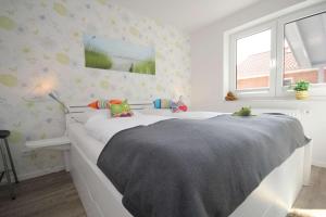 a bedroom with a bed with stuffed animals on it at Feriendorf Südstrand Haus 11 in Pelzerhaken