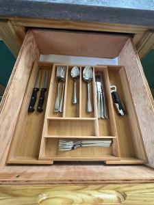 a wooden lunch box with cutlery in it at Windy Nook - The Contemporary Tiny Home in Saint Philip