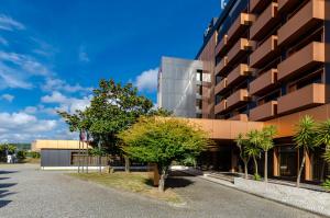 a building with a tree in front of it at TURIM Santa Maria da Feira Hotel in Santa Maria Da Feira