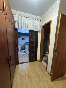 a hallway with a door to a room with a window at Predinho do Guaratuba in Guaratuba