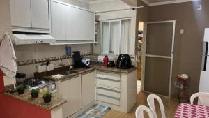 a kitchen with white cabinets and a counter top at Predinho do Guaratuba in Guaratuba