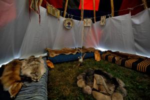 a cat laying on a blanket in front of a tent at Fort Wapiti in Zalasowa