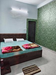 a bedroom with a bed with a green wall at Shiv Lehri Homestay in Ujjain +2 photos