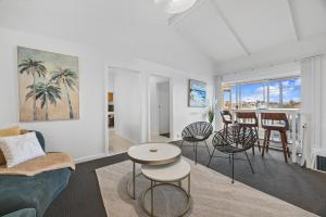 a living room with a couch and a table and chairs at Sunset Seas in West Beach in West Beach