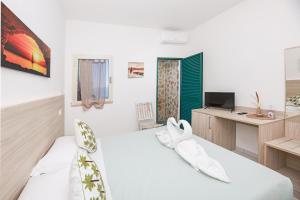 a living room with a couch and a desk at Hotel Le Ghiaie in Portoferraio