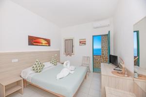 a bedroom with a bed with a stuffed animal on it at Hotel Le Ghiaie in Portoferraio