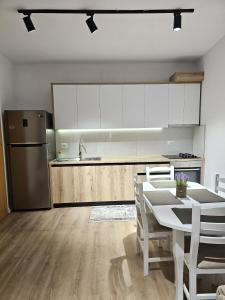 a kitchen with a white table and a refrigerator at Tirana Apartment in Kashari +16 photos