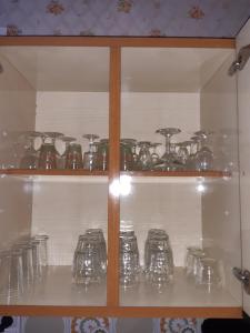 a shelf filled with glasses and other glass items at Gîte la fourmilière in Morbier