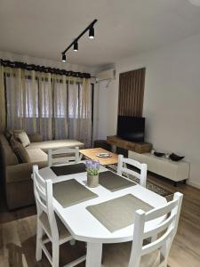 a living room with a white table and chairs at Tirana Apartment in Kashari
