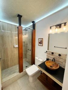 a bathroom with a sink and a toilet and a shower at Toliman Room in San Lucas Tolimán +9 photos