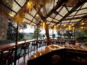 a restaurant with a bar with a view of the water at Toliman Room in San Lucas Tolimán