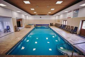 a large swimming pool with blue water in a building at Pensiunea ALDA in Suceviţa