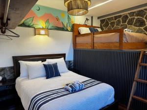 a bedroom with two bunk beds and a white bed at Garden Gathering Room in San Lucas Tolimán