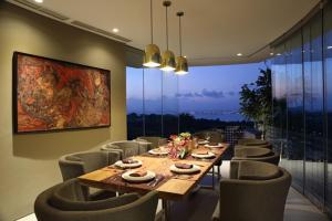a dining room with a long table and chairs at Dacolina House Jimbaran in Jimbaran