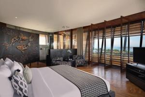 a bedroom with a large bed and a living room at Dacolina House Jimbaran in Jimbaran +14 photos